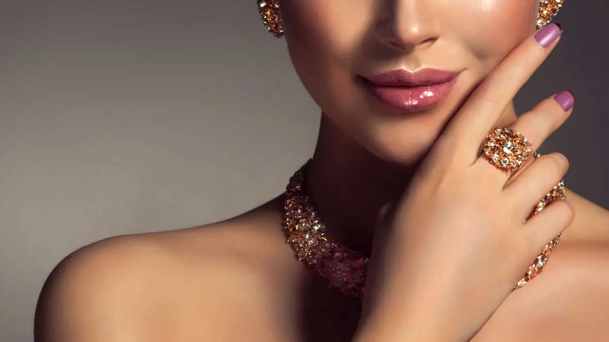 Eine Frau trägt Diamantenschmuck. Ohrschmuck, Halskette und Ringe