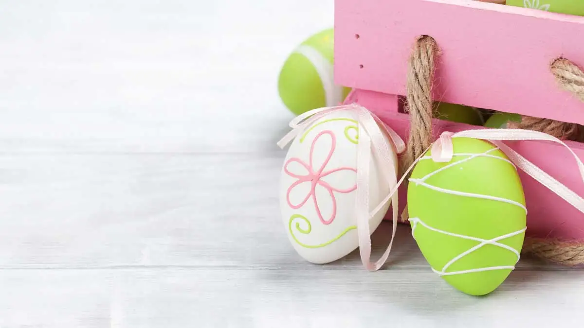 Zwei bunte Ostereier und ein Geschenkkorb